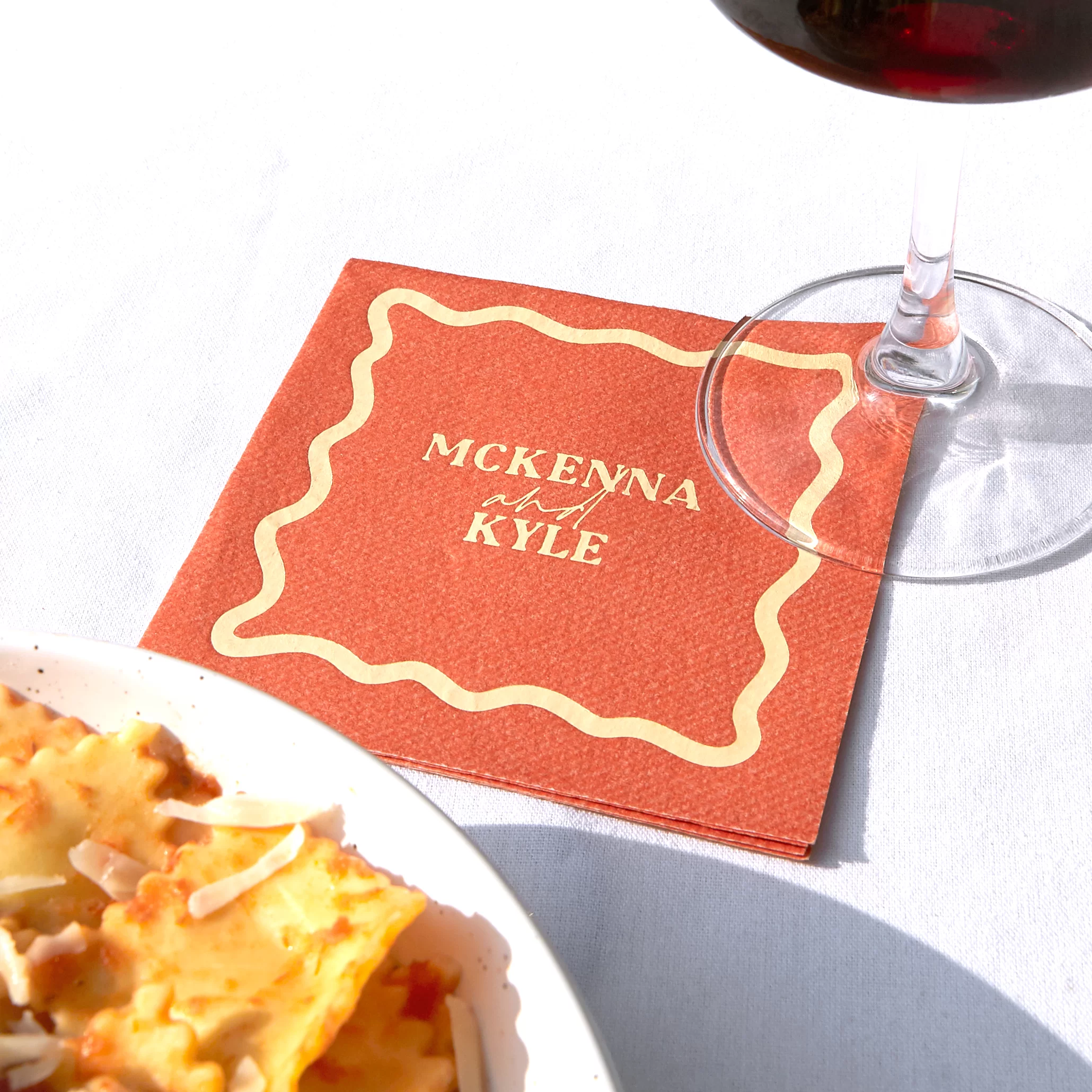 Styled image with custom cocktail napkin and a wine glass