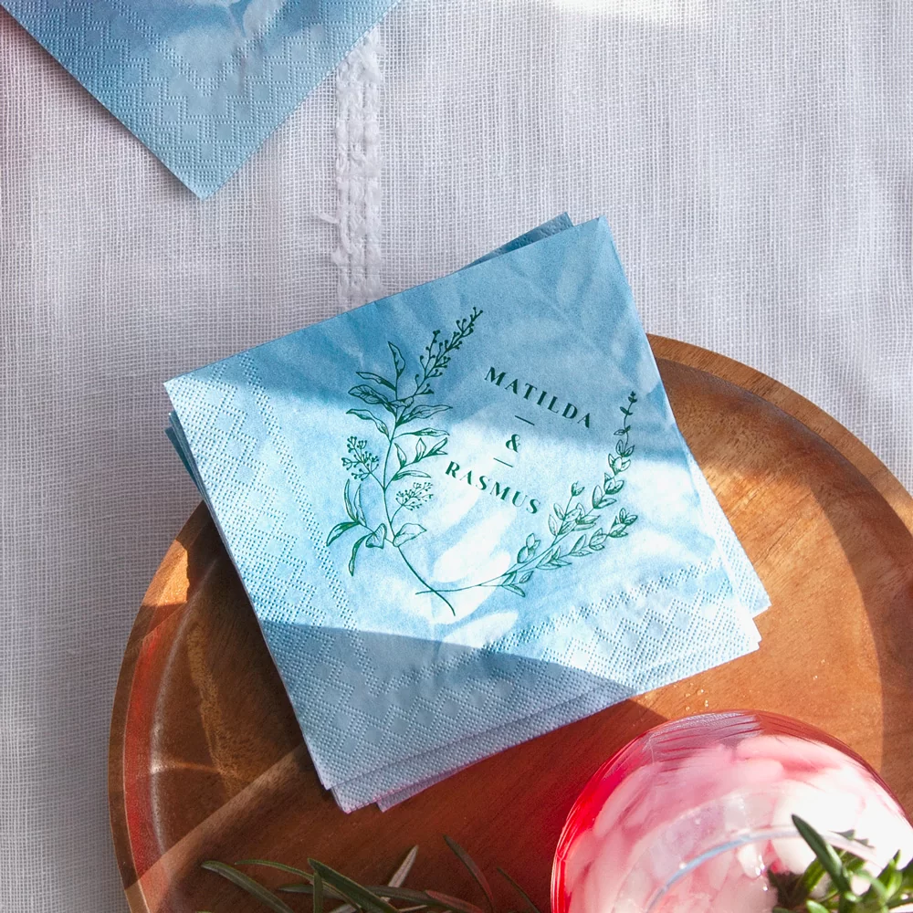blue napkin printed in gold with floral crest and couple's names