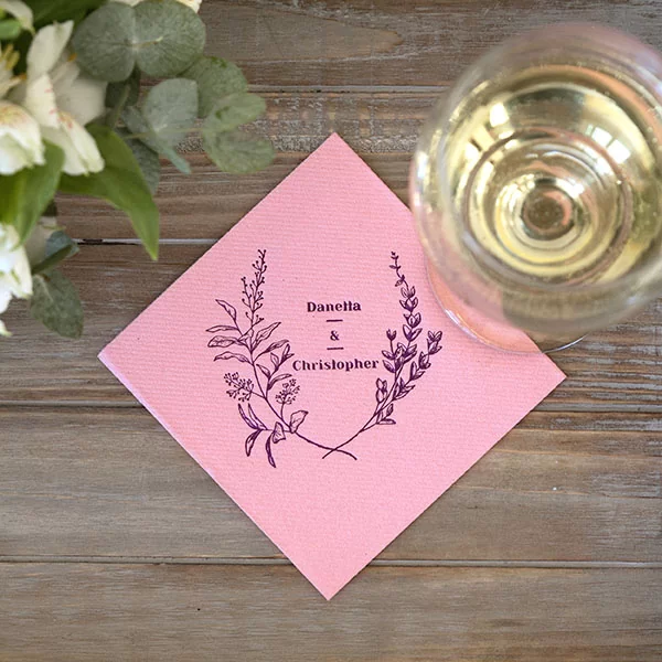 pink napkin printed in gold with floral crest and couple's names