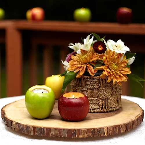fall centerpiece with apples, flowers and diy votive candle holders