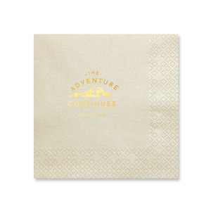The Adventure Continues Napkin design encapsulates the spirit of exploration and shared journey. Featuring a graphic of snow-capped mountains with "The Adventure" arching over and "CONTINUES" below, it symbolizes the ongoing journey of the couple. Their names personalize this narrative of continuous adventure and discovery as they embark on life together. 