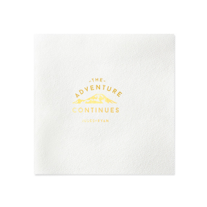 The Adventure Continues Napkin design encapsulates the spirit of exploration and shared journey. Featuring a graphic of snow-capped mountains with "The Adventure" arching over and "CONTINUES" below, it symbolizes the ongoing journey of the couple. Their names personalize this narrative of continuous adventure and discovery as they embark on life together. 
