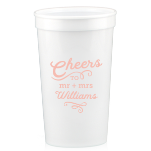 The Swirling Cheers Cup exudes exuberance. The design features "Cheers" fancifully scripted, underscored by a flourish. Below, the couple's titles "Mr. and Mrs." lead into their last name, further accentuated by an ornate flourish. These swirling designs add a sense of fanciful charm, making the cup a perfect vessel for toasting. 
