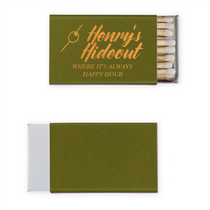 This Martini Pick Where It's Always Happy Hour Matchbox features bold script reading “Henry’s Hideout,” a martini olive pick icon, and the phrase “Where It’s Always Happy Hour” in warm golden lettering. Create a fun, personalized bar vibe guests will love. Perfect for weddings, birthdays, or bachelor parties.