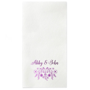 The Garden Flourish Napkin design exudes old-world romance. The couple's names are elegantly scripted in a swirling, romantic font. Below, a whimsical cascade of florals and greenery, dotted with hidden hearts and interspersed flowers, evokes the charm of a bride's cascading bouquet.