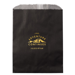 The Adventure Continues Bag encapsulates the spirit of exploration and shared journey. Featuring a graphic of snow-capped mountains with "The Adventure" arching over and "CONTINUES" below, it symbolizes the ongoing journey of the couple. Their names personalize this narrative of continuous adventure and discovery as they embark on life together. 