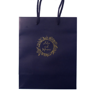 The Regal Wreath Bag design presents an elegant and abundant floral wreath, symbolizing luxury and nature's richness. Enclosed within this lush botanical embrace, the couple's names are elegantly scripted, adding a touch of royal sophistication. This design artfully marries opulence with the charm of natural abundance.