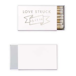 Ignite romance with the Love Struck Banner Matchbox featuring the smitten phrase above a banner cradling your special date. This design charmingly captures the couple's love, making each strike a celebration of their union.