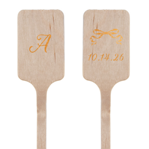 The Bow-Tied Date Stir Stick features a graceful bow graphic atop one side, with the flip side showcasing your initial in an ornate, yet understated script. This elegant stirrer adds a touch of charm to any celebration, making it an ideal keepsake for guests to remember your occasion by. Perfect for adding a touch of sophistication to weddings, anniversaries, or elegant soirees.