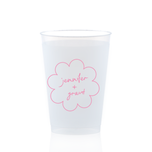 Sip in style at your whimsical wedding with the Kitschy Cocktail Hour Floral Frame Cup. Personalize this charming vessel with the couple's names, elegantly scripted within a blooming flower-shaped frame. A modern and enchanting choice for your celebratory toasts.