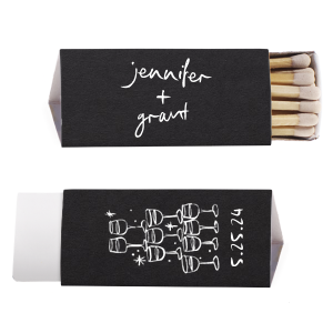  Light up the night with the Kitschy Cocktail Hour Toasting Glasses Matches, a whimsically modern addition to your wedding day. Each matchbox, personalized with the couple's names in a hand-drawn-inspired script, flips to reveal a contemporary line drawing of a wine glass pyramid and the date, perfect for commemorating your toast to forever.