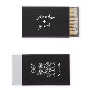  Light up the night with the Kitschy Cocktail Hour Toasting Glasses Matches, a whimsically modern addition to your wedding day. Each matchbox, personalized with the couple's names in a hand-drawn-inspired script, flips to reveal a contemporary line drawing of a wine glass pyramid and the date, perfect for commemorating your toast to forever.