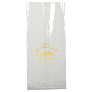 The Adventure Continues Bag encapsulates the spirit of exploration and shared journey. Featuring a graphic of snow-capped mountains with "The Adventure" arching over and "CONTINUES" below, it symbolizes the ongoing journey of the couple. Their names personalize this narrative of continuous adventure and discovery as they embark on life together. 