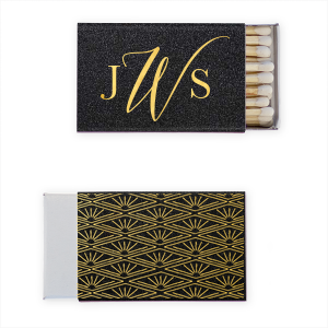 Experience the allure of the Deco Monogram Match, where classic monograms meet Art Deco sophistication. The front showcases monogrammed initials with a striking, curved centerpiece. The back is adorned with symmetric line art and Egyptian-inspired sunbursts, making this matchbox a statement piece for any event, exuding timeless elegance and ornate style.