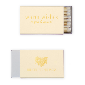 Ignite a hearthside glow with the Warm Wishes Matchbox, extending a toasty greeting to all. The family name and pinecone cluster on the reverse side kindle the essence of homely cheer, perfect for fireside gatherings and festive nights.