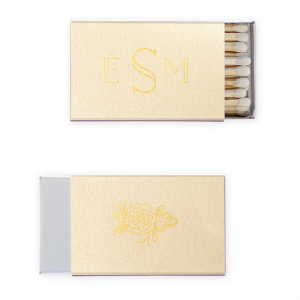 The Monogram Flower Matchbox design combines simplicity with elegance. On one side, a modern monogram in a refined font represents the couple. The other side features a single peony, symbolizing love, honor, and joy, amidst lush greenery. This matchbox is a subtle yet meaningful nod to lasting love and beauty.