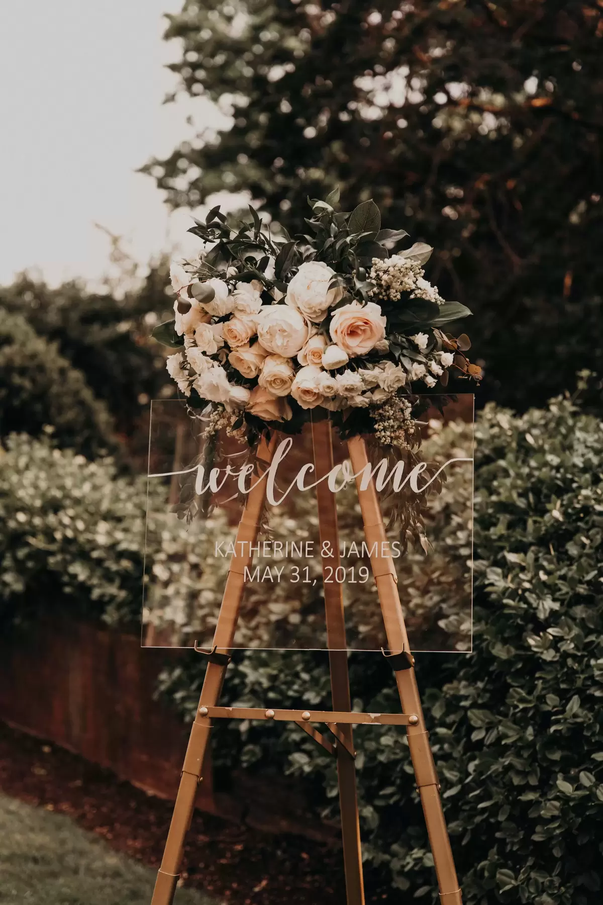 acrylic welcome sign at elegant outdoor wedding