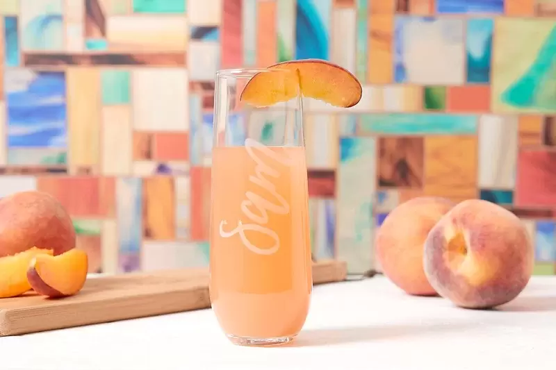 refreshing peach bellini served in custom champagne glass from For Your Party