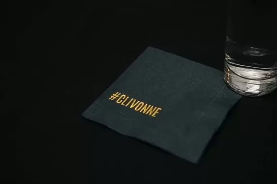A black cocktail napkin with the couple's hashtag