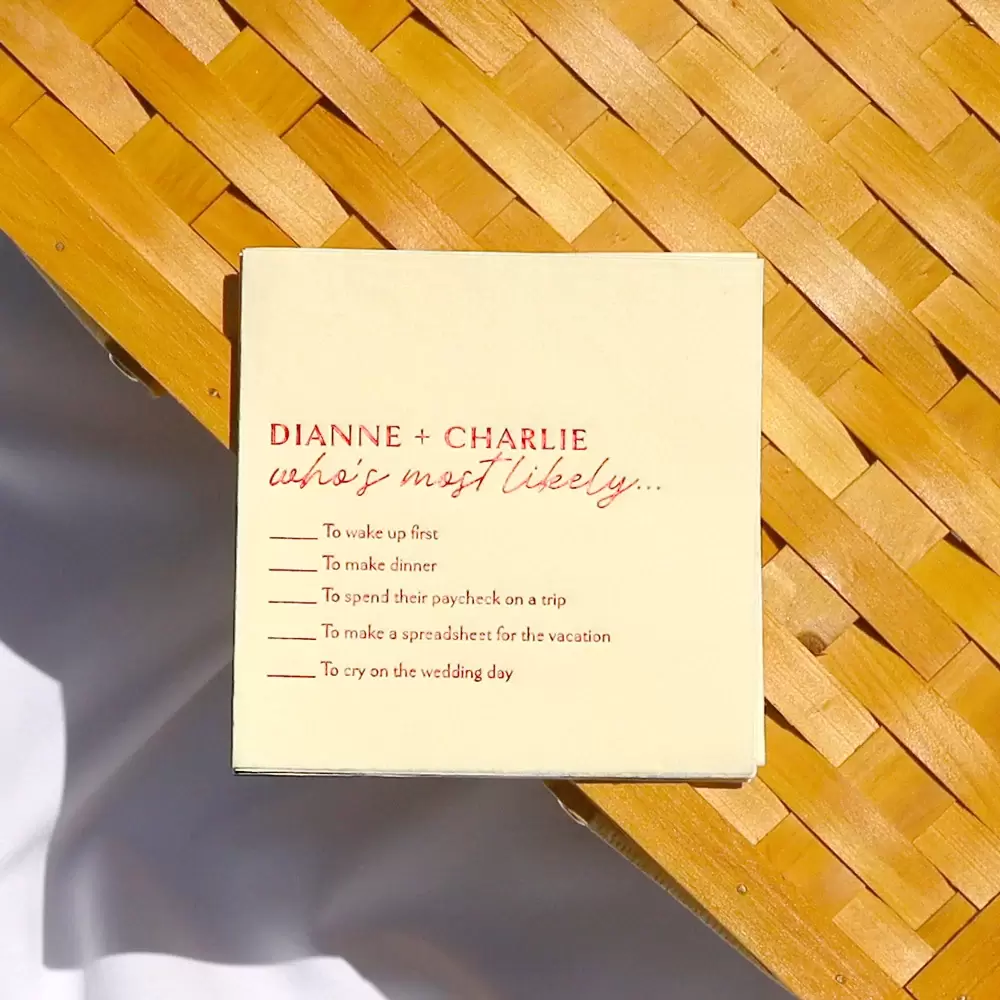 Close-up of game custom cocktail Napkin that says “Dianne & Charlie: Who’s Most Likely to”