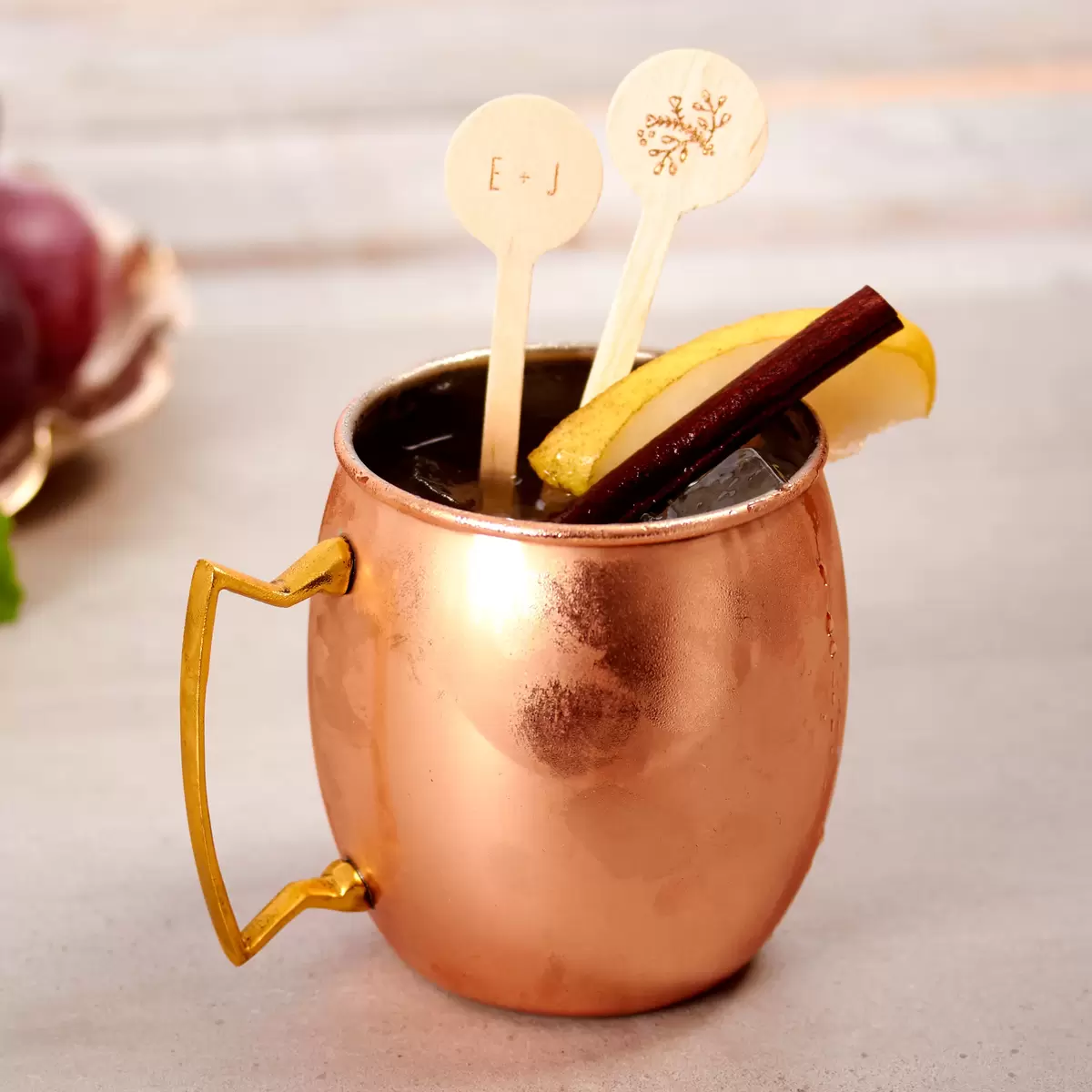 fall moscow mule that is a spiced moscow mule with pears, cinnamon and a personalized wooden drink stirrer